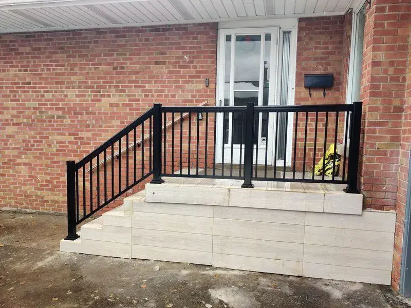 Black aluminum railing on one side of a porch (Id A-279)